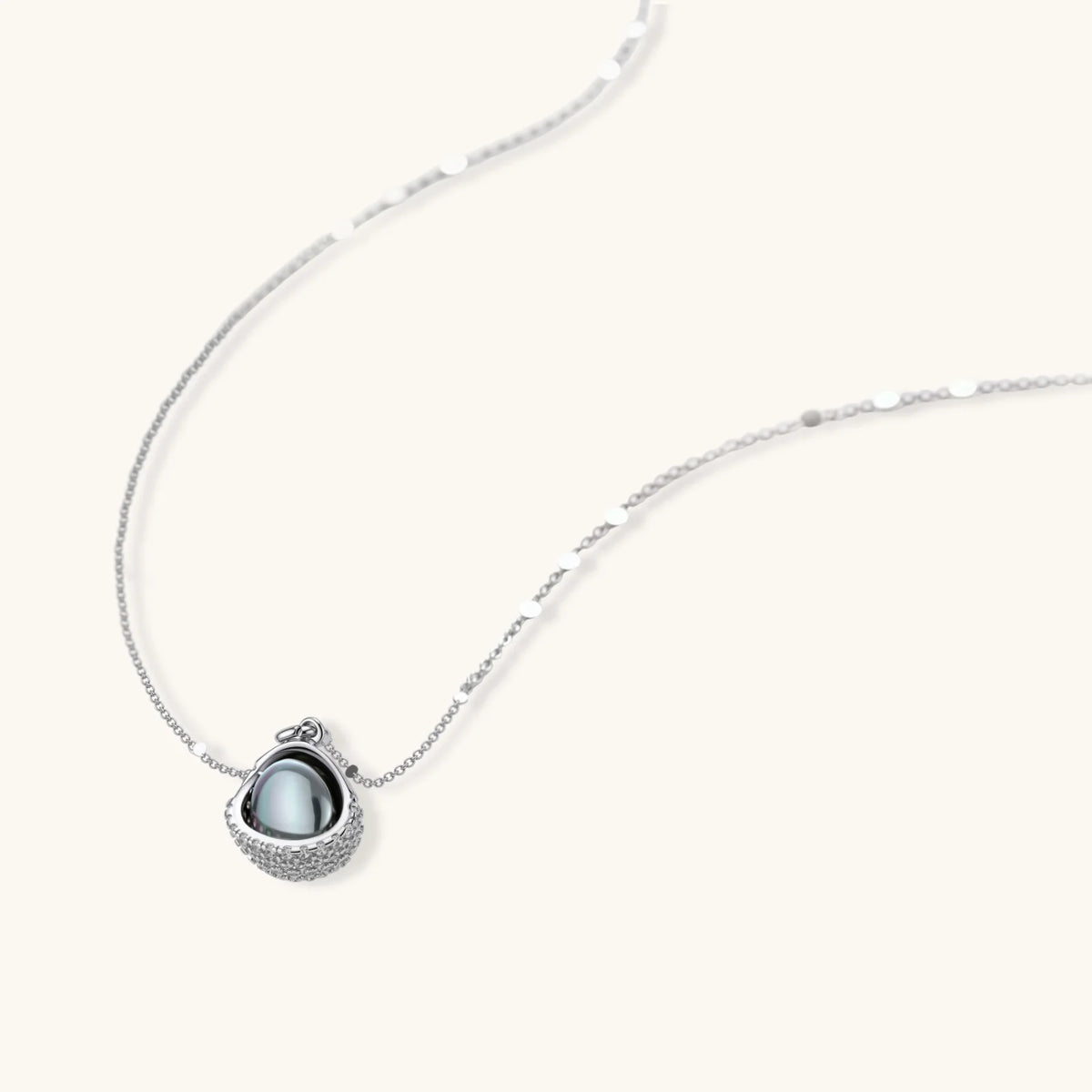Necklace and stud earrings set with silver-gray domed centers in white gold plated eco-brass shells pavé-set with zirconia.