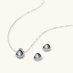 Necklace and stud earrings set with silver-gray domed centers in white gold plated eco-brass shells pavé-set with zirconia.
