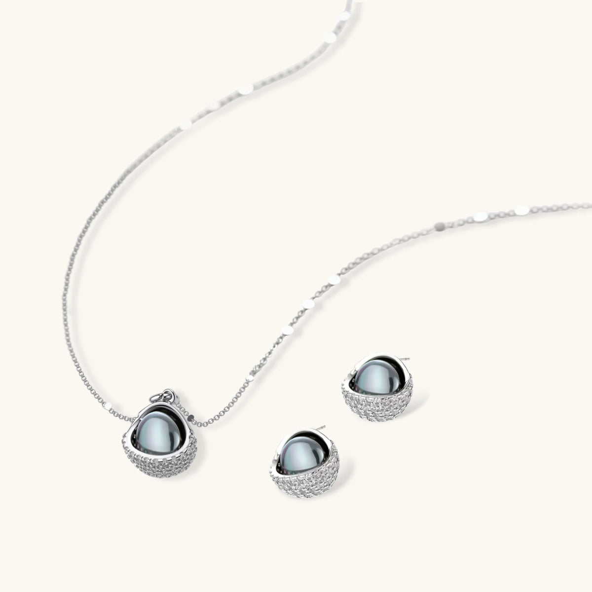 Necklace and stud earrings set with silver-gray domed centers in white gold plated eco-brass shells pavé-set with zirconia.