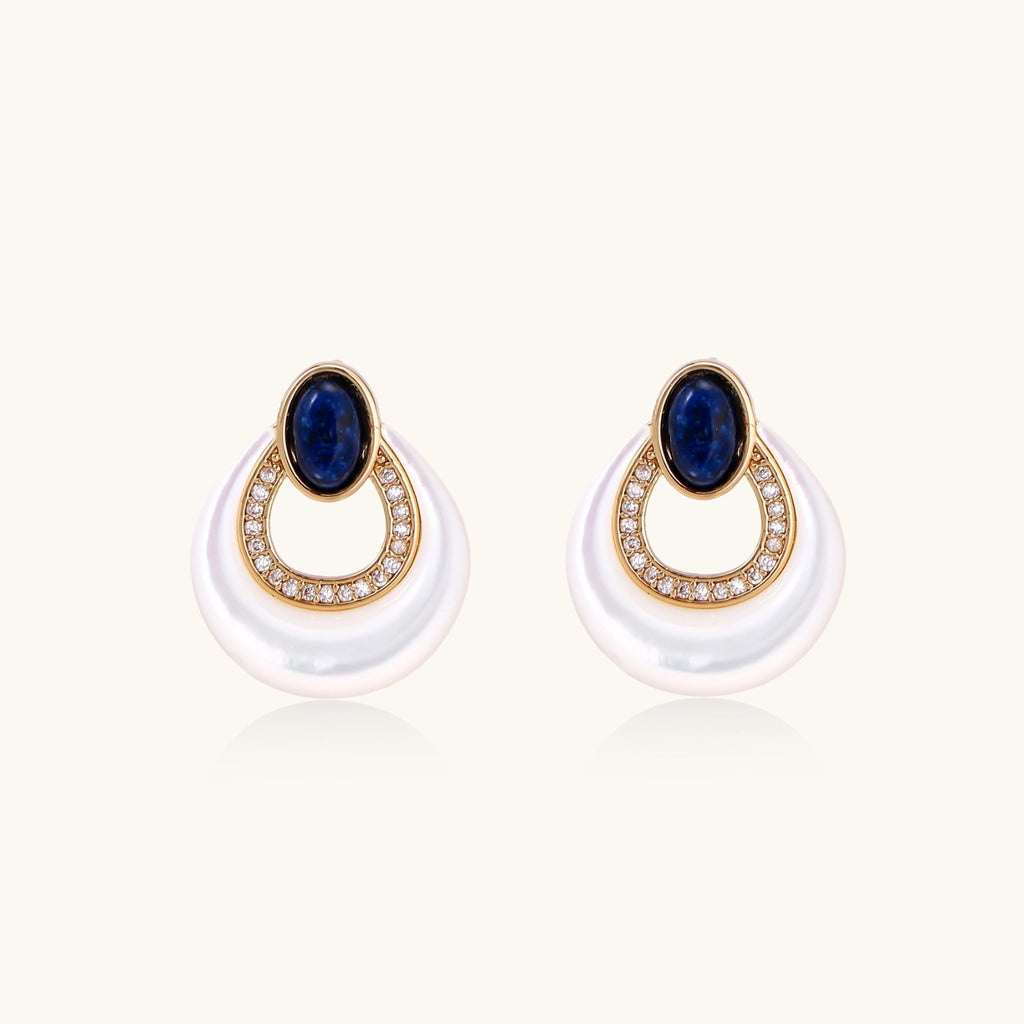 Gold plated stud earrings with an oval lapis lazuli top, CZ-lined teardrop loop and white MOP crescent on a cream background.