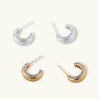 Close-up of small silver-plated hoop earrings with brushed texture and a row of sparkling zircon crystals on white background